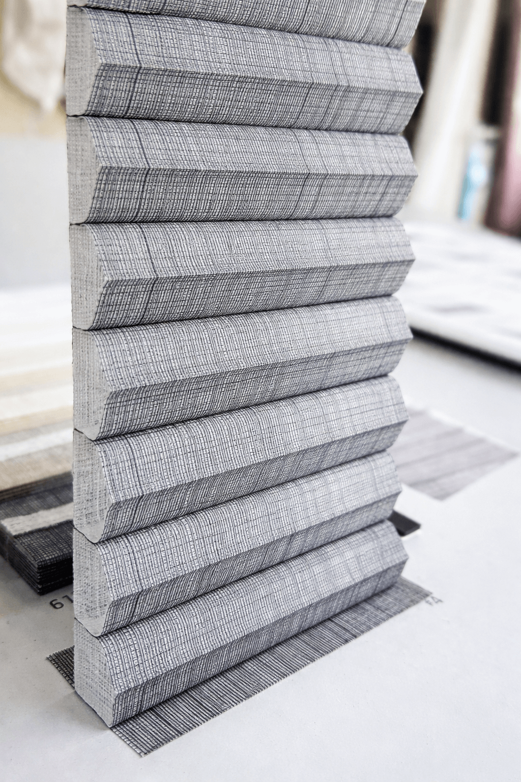 blind-sample.jpg תקריב של בד וילון פליסה אפור עם טקסטורה מובלטת להמחשת איכות הבד והקיפול.