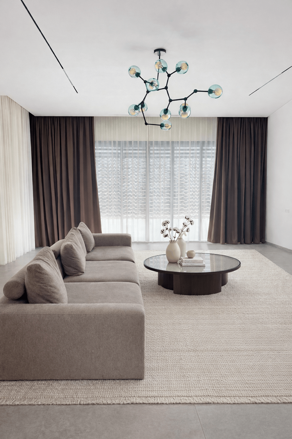 וילונות לסלון בשילוב צבעים של חום כהה ולבן עם גוף תאורה מעוצב וספה אפורה.