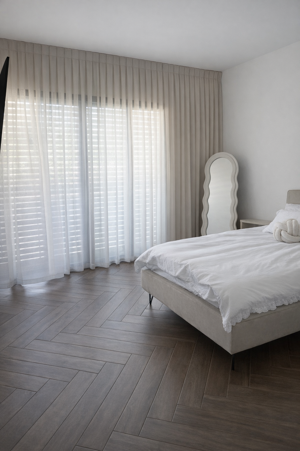 וילונות לחדר שינה מבד שקוף ולבן מקיר לקיר, בחדר עם רצפת פרקט בדוגמת פישבון ומראה גלית.
