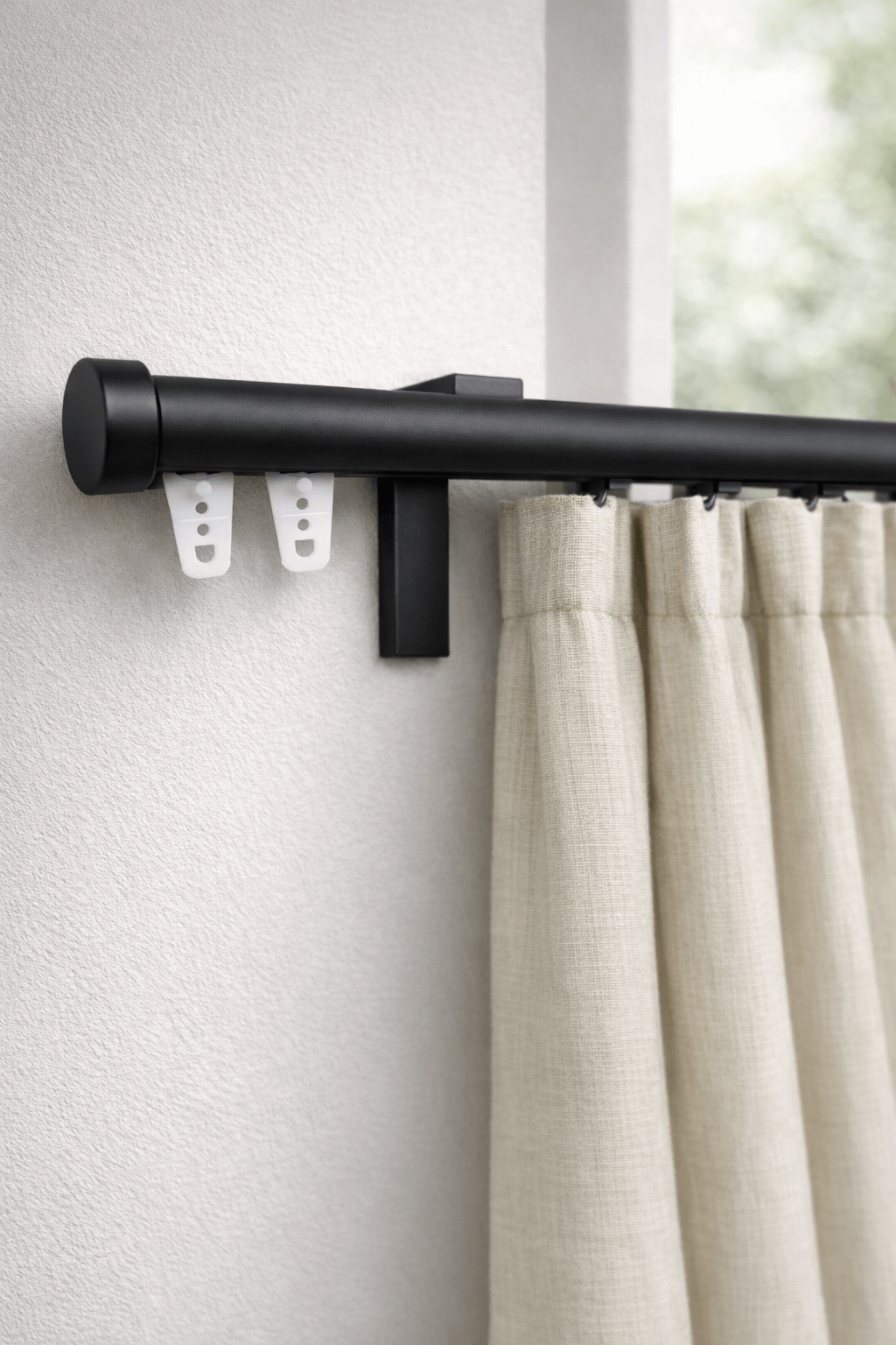 וט וילון שחור מט עם סיומת עגולה ווילון בהיר, מותקן על קיר לבן.