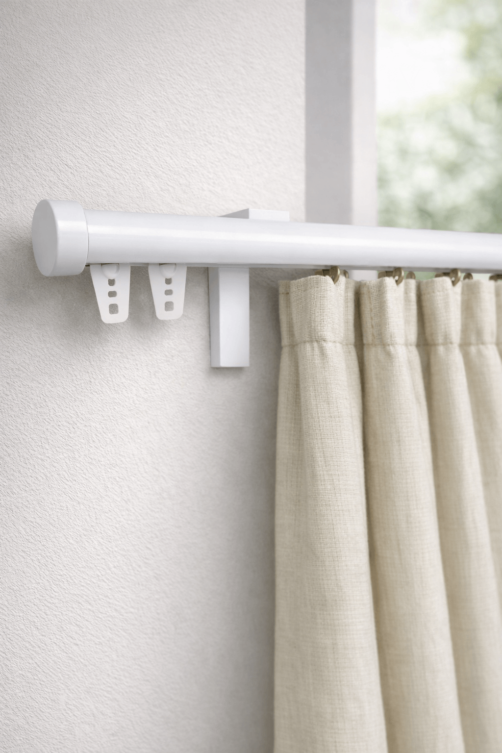 מוט וילון לבן מינימליסטי המשתלב בקיר לבן עם וילון פשתן בהיר.