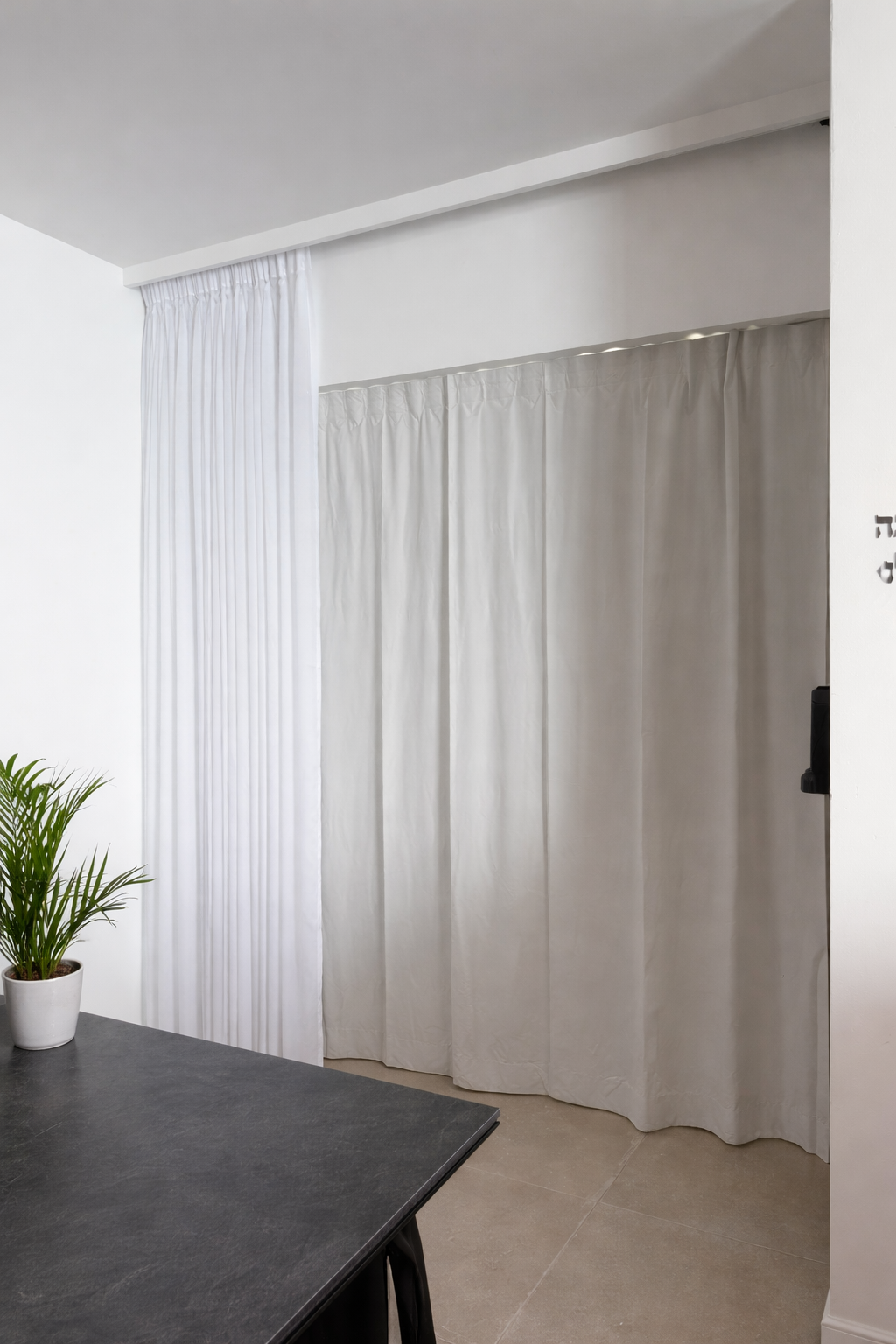 וילון רומי בגוון חול בחדר ילדים מעל מיטה עם בובת ארנב לבנה.